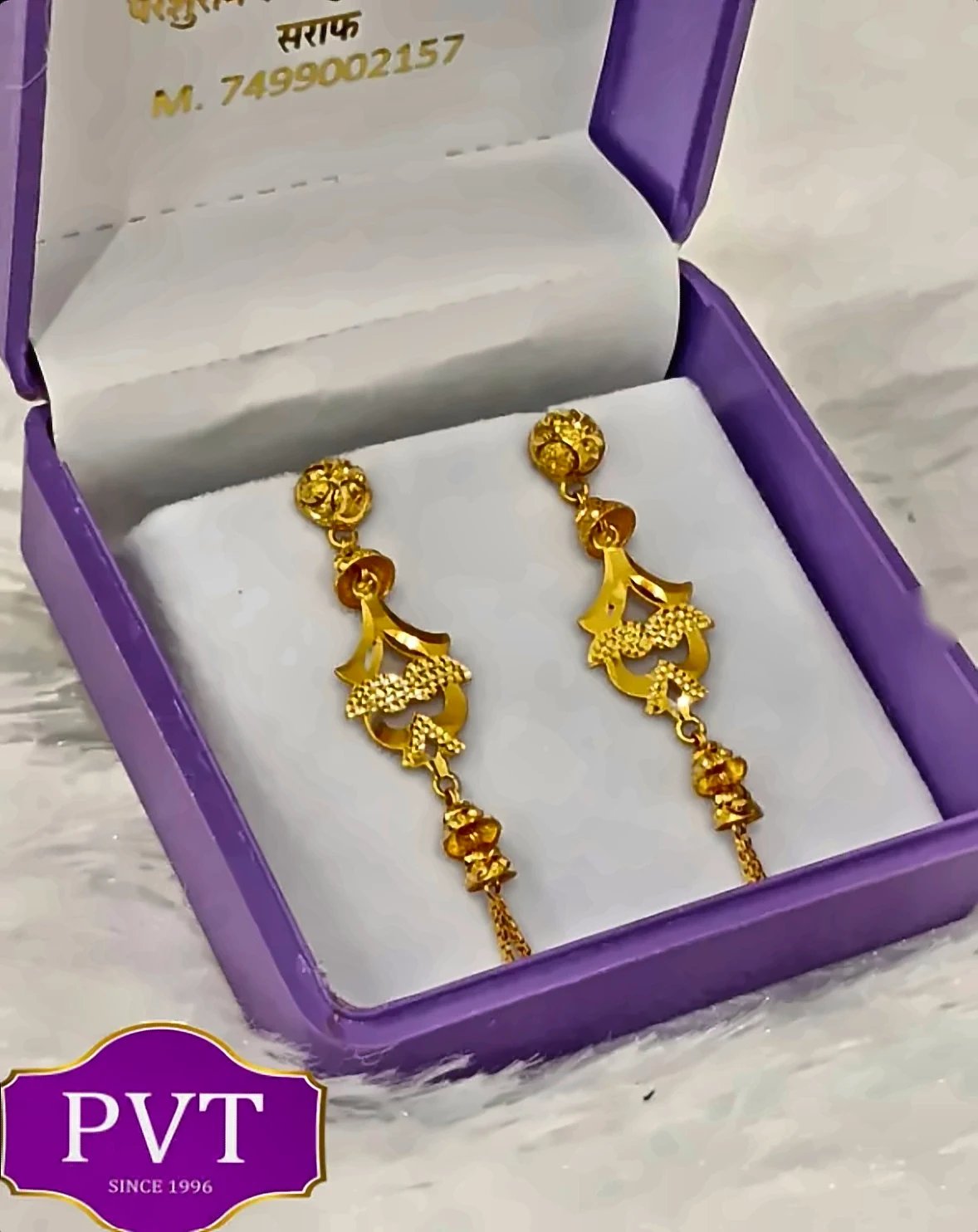 Gold drop earrings with decorative motifs and fine tassel chains in a PVT gift box